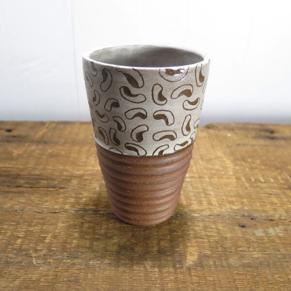 Red clay ceramic tumbler with a white bean pattern.
