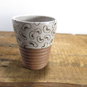 Red clay ceramic tumbler with a white bean pattern.
