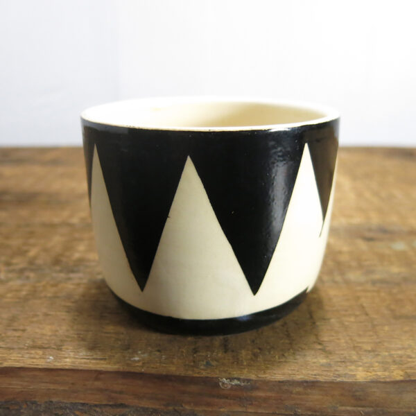 Black and white ceramic cup with a triangle pattern.