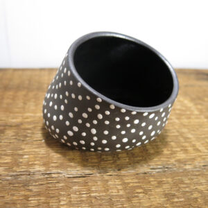 Black clay ceramic dish with white dots and glossy black interior.
