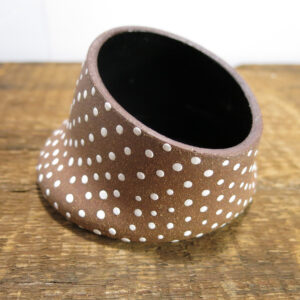 Red clay ceramic dish with white dots and glossy black interior.