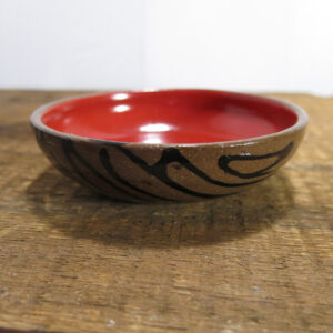 Small ceramic sauce bowl. Glossy red glaze inside.