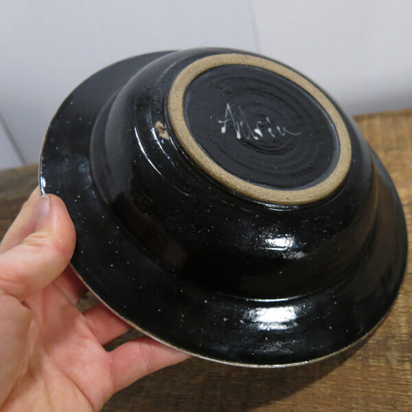 Underside of the wide-brimmed bowl, shinny black.