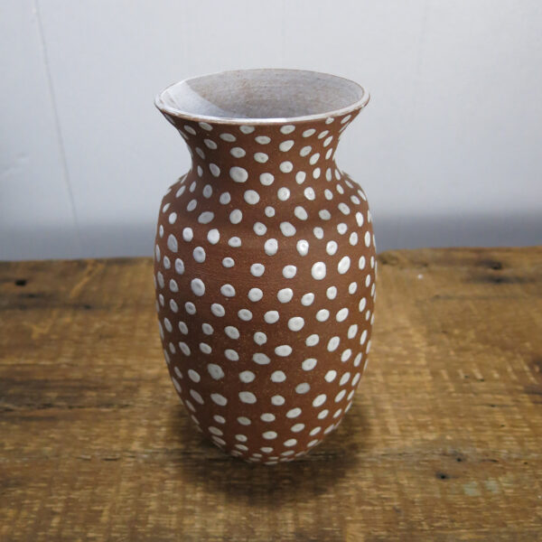 Red clay vase with white spots.