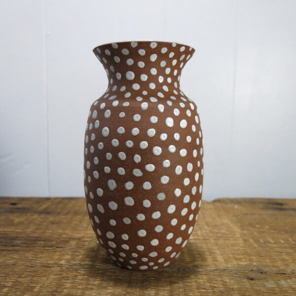 Red clay vase with white spots.