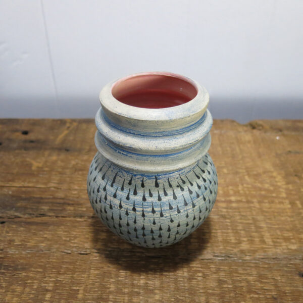 Blue and pink ceramic vase with black textured pattern.