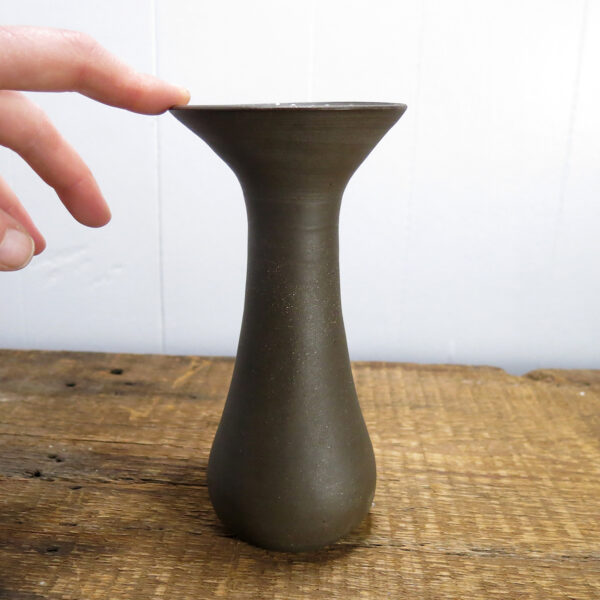 A ceramic vase made of black clay, decorated with small white dots.