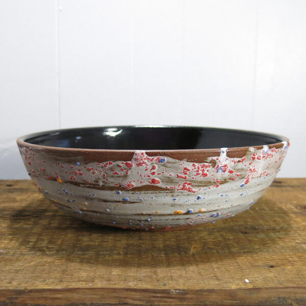 Large ceramic bowl with textured exterior and black glossy interior.