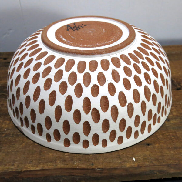 Large white and red/brown carved ceramic bowl, shown upside down.