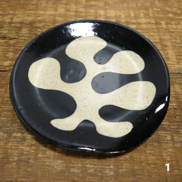 The first buff ceramic spoon rest with an organic black decoration.
